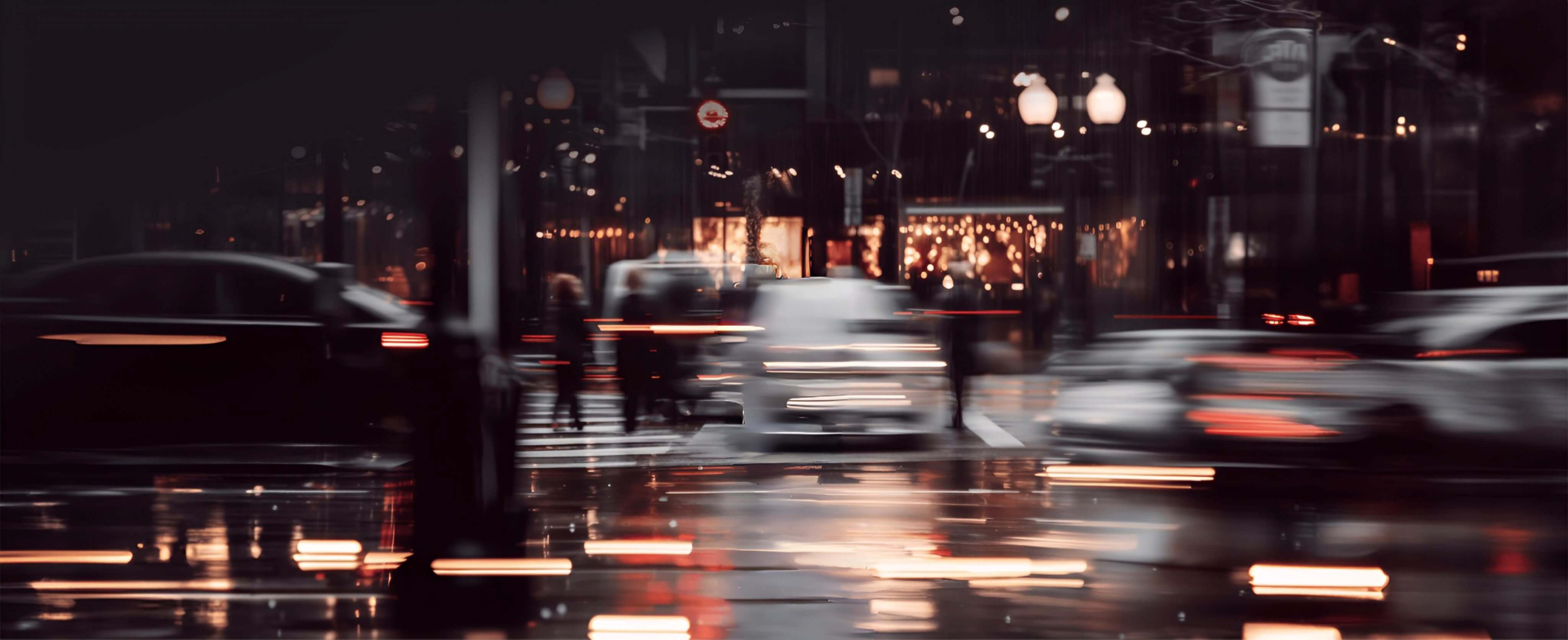 A background view of a city street at night with blurred car lights and a dark ambiance.