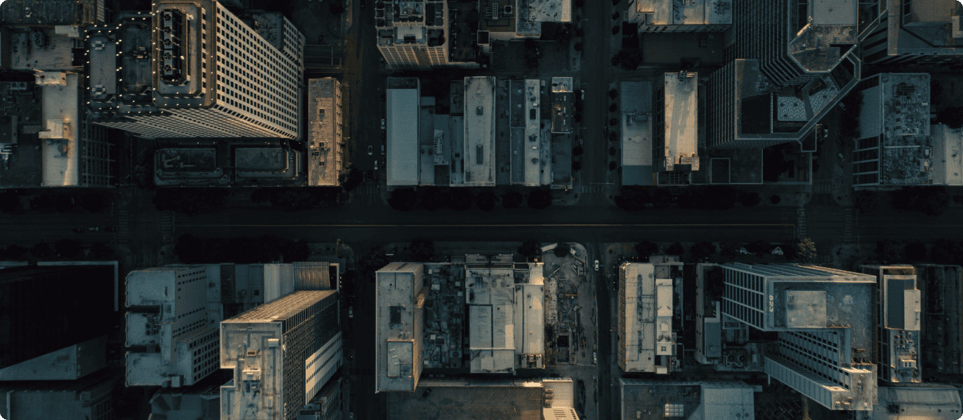 Aerial view of the city displaying its streets and tall buildings with dim nighttime lighting